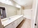 Bright bathroom featuring double sinks, large mirror, tiled floor, and shower-tub combination at 5271 Aurora Beam Ave, Las Vegas, NV 89122
