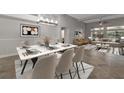 Bright dining area featuring a table with six chairs, modern chandelier, and seamless transition into the living space at 6012 Chessington Ave, Las Vegas, NV 89131