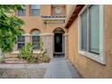 Charming home entryway with stone accents, arched windows and desert landscaping at 7216 Campolina Ct, Las Vegas, NV 89113