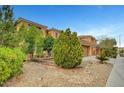 Street view of a two-story home with desert landscaping including trees, bushes and rock groundcover at 7216 Campolina Ct, Las Vegas, NV 89113