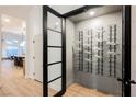 Custom wine cellar features modern door and storage racks at 7695 Silver Wells Rd, Las Vegas, NV 89149