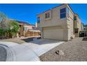 Two-story home with a two-car garage features desert landscaping at 8329 Telescope Peak Ct, Las Vegas, NV 89145