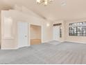 Bright living room with neutral carpet, a high ceiling, and large windows, offering lots of natural light at 8912 Galena Crossing St, Las Vegas, NV 89123