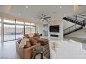 Bright living room boasts floor-to-ceiling windows, modern fireplace, and staircase to the upper level at 9780 Solar Ave, Las Vegas, NV 89149
