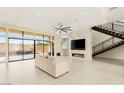 Bright living room featuring marble fireplace, staircase, and large sliding glass doors at 9780 Solar Ave, Las Vegas, NV 89149