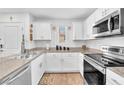 Bright kitchen featuring stainless steel appliances, white cabinetry, and solid surface countertops at 12126 Azure Gate Rd # 1, Las Vegas, NV 89183
