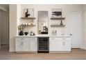 Stylish bar area featuring a wine refrigerator, floating shelves, and elegant decor at 1624 Preston Park Dr, Henderson, NV 89052