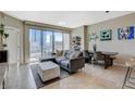 Open living space with a gray sofa, city views, and dining area adjacent to the kitchen at 222 Karen Ave # 1804, Las Vegas, NV 89109