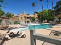 Inviting community pool with lounge chairs, tables and well-maintained landscaping at 230 Mission Catalina Ln # 204, Las Vegas, NV 89107