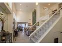 View of a living room from the staircase, featuring high ceilings and a fireplace at 2649 Golden Sands Dr, Las Vegas, NV 89128