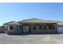 Attractive front exterior featuring a tile roof, double-door entry, and desert landscaping at 3020 Peggy Ave, Pahrump, NV 89048