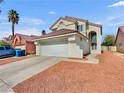 Home exterior featuring a two-car garage, desert landscaping, concrete driveway and pathway at 3444 Trilogy Dr, Las Vegas, NV 89108
