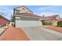 Home with a two car garage, desert rock landscaping, and concrete driveway at 3444 Trilogy Dr, Las Vegas, NV 89108