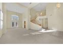 Large living room featuring vaulted ceilings, a staircase and neutral tones at 3755 Broadmead St, Las Vegas, NV 89147