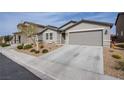 View of the home's exterior showing the driveway and the low-maintenance front yard at 412 Horsetail Falls St, Indian Springs, NV 89018