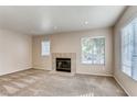 Living room featuring plush carpet, neutral walls, and a cozy fireplace at 447 Temple Canyon Pl, Henderson, NV 89074