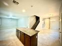 Open-concept living space with tile flooring, a center kitchen island, and natural light at 6639 Ivory Dove Ct, Las Vegas, NV 89148