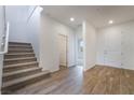 Bright foyer featuring wood-look tile floors, carpeted stairs and white trim at 785 Black Palace St, Henderson, NV 89011