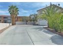 Home featuring a spacious driveway with palm trees adding to its curb appeal at 9509 Arrowhead Falls Ct, Las Vegas, NV 89148