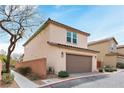 Two-story home with attached garage, featuring desert landscaping and a brick surround at 10943 Ketchikan St, Las Vegas, NV 89179