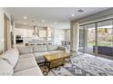 Open-concept living room with a comfortable sectional sofa, stylish rug, and access to the backyard at 11137 Black Fire Opal Dr, Las Vegas, NV 89138
