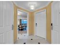 Hallway with white tile floors and doors leading to living area with beautiful city views at 125 E Harmon Ave # 2220, Las Vegas, NV 89109