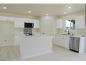Bright kitchen with stainless steel appliances, white cabinets, an island, and modern countertops at 220 N David St, Pahrump, NV 89060