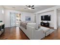 Spacious living room with hardwood floors, large sectional sofa, recessed lighting, and slider doors at 3239 Robins Creek Pl, Las Vegas, NV 89135