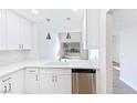 Modern kitchen with white cabinets, stainless steel appliances, and a view to the backyard through sliding glass doors at 3339 Duece St, Las Vegas, NV 89121