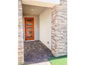 Inviting front entryway with a stylish orange door and decorative stone columns at 600 N Carriage Hill Dr # 1019, Las Vegas, NV 89138