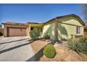 Inviting single-story home with a two-car garage, lush landscaping, and a well-manicured lawn at 6520 Ouida Way, Las Vegas, NV 89108