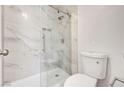 Bright bathroom featuring tiled shower with glass door and modern toilet at 689 Hitchen Post Dr, Henderson, NV 89011
