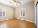 Cozy bedroom features wood floors, ceiling fan and shuttered windows at 6982 Mirkwood Ave, Las Vegas, NV 89178