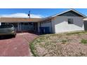 Exterior shot showcasing a garage, blue trash cans, and desert landscaping at 709 Scholl Dr, Las Vegas, NV 89107