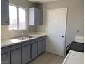 Functional kitchen with gray cabinetry, a stainless steel sink, and ample counter space at 709 Scholl Dr, Las Vegas, NV 89107
