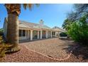 Expansive backyard featuring a covered patio, desert landscaping and mature trees for backyard privacy at 8813 Sundial Dr, Las Vegas, NV 89134