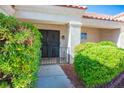 Welcoming home entrance with security gate surrounded by lush greenery and decorative rock ground cover at 8813 Sundial Dr, Las Vegas, NV 89134