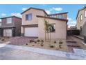 New two-story home with two car garage and desert landscaping with young trees at 9283 Lunar Phase St, Las Vegas, NV 89143