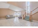 Bright living room with tile flooring, a staircase, and large windows with plantation shutters at 1009 Nawkee Dr, North Las Vegas, NV 89031