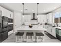 Modern kitchen features white cabinets, a large center island with seating, stainless steel appliances, and pendant lighting at 10101 Heron Lake Ave, Las Vegas, NV 89178