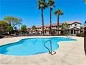 Community pool surrounded by palm trees and well-maintained landscaping, creating a relaxing and inviting atmosphere at 1129 Paradise Vista Dr, Henderson, NV 89002