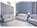 Relaxing living room featuring grey sofas, a neutral rug, light grey flooring, and bright natural light at 1142 Teal Point Dr, Henderson, NV 89074
