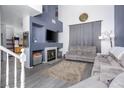Cozy living room with fireplace, grey sofas, tall ceilings, and a large blue accent wall at 1142 Teal Point Dr, Henderson, NV 89074