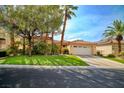 Lovely single-story home with lush landscaping, mature trees, and a two-car garage at 129 Chateau Whistler Ct, Las Vegas, NV 89148