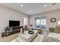 Inviting living room with hardwood floors, recessed lighting, a large tv and access to a sunroom at 1372 Couperin Dr, Henderson, NV 89052