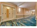 Wide hallway with ornate, patterned, aqua colored carpet; doors on left and right; peach walls at 145 E Harmon Ave # 3101, Las Vegas, NV 89109