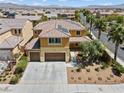 Aerial view of a two-story tan home with a three-car garage, desert landscaping, and a tile roof at 1776 Gentle Brook St, North Las Vegas, NV 89084
