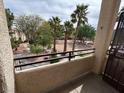 View from condo balcony overlooking landscaped common area with mature palm trees at 1830 N Buffalo Dr # 2098, Las Vegas, NV 89128