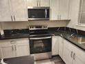 Modern kitchen featuring white cabinets, stainless steel appliances, and beautiful black countertops at 4128 Annie Oakley Dr, Las Vegas, NV 89121