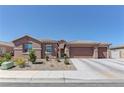 Inviting single-story home with a desert landscape, long driveway, and attached garage at 5629 Portage Lake Ct, Las Vegas, NV 89130